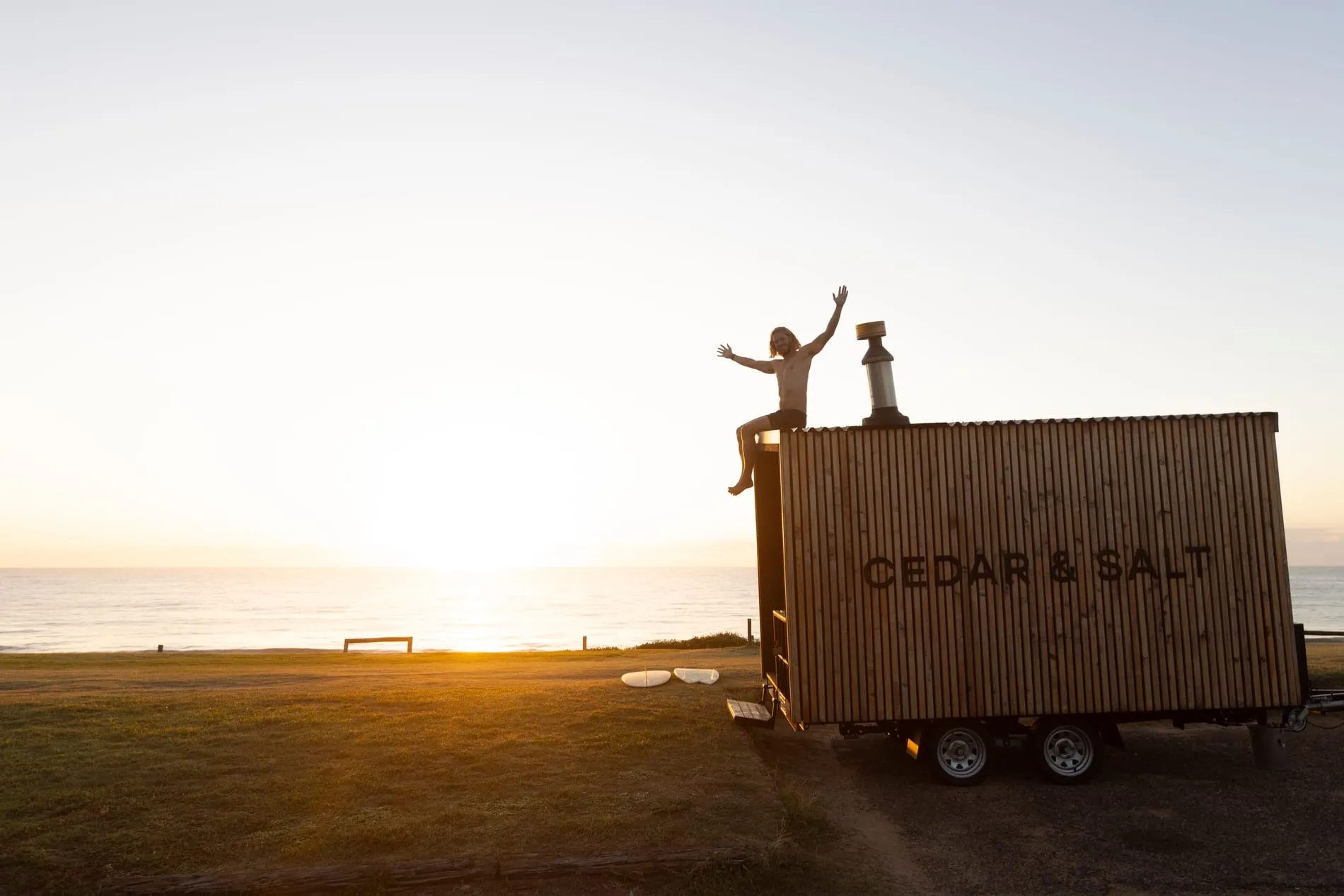 A wood-fired mobile sauna at sunset on an Australian beach