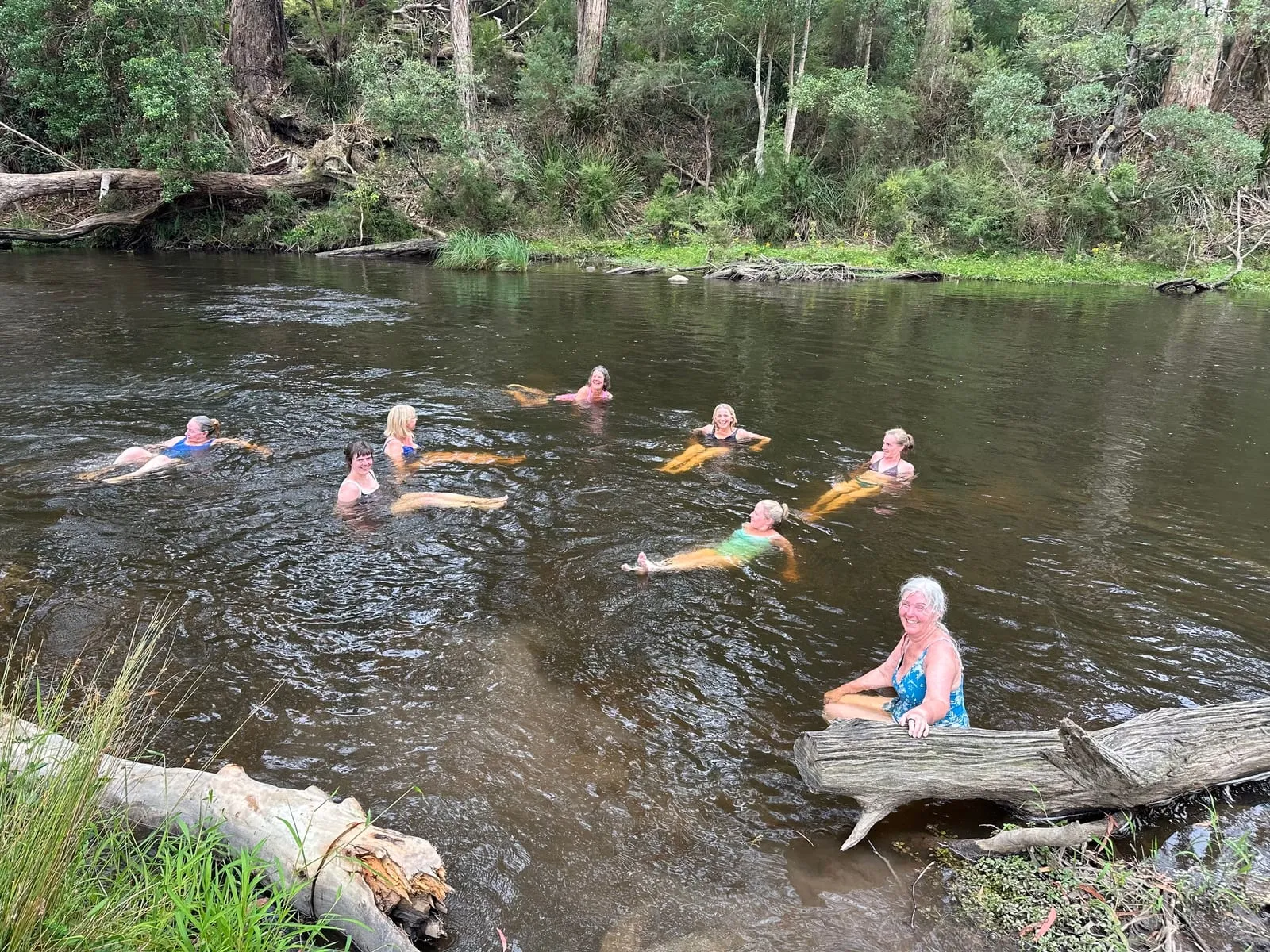 Bathers cold-plunging in a river after the sauna